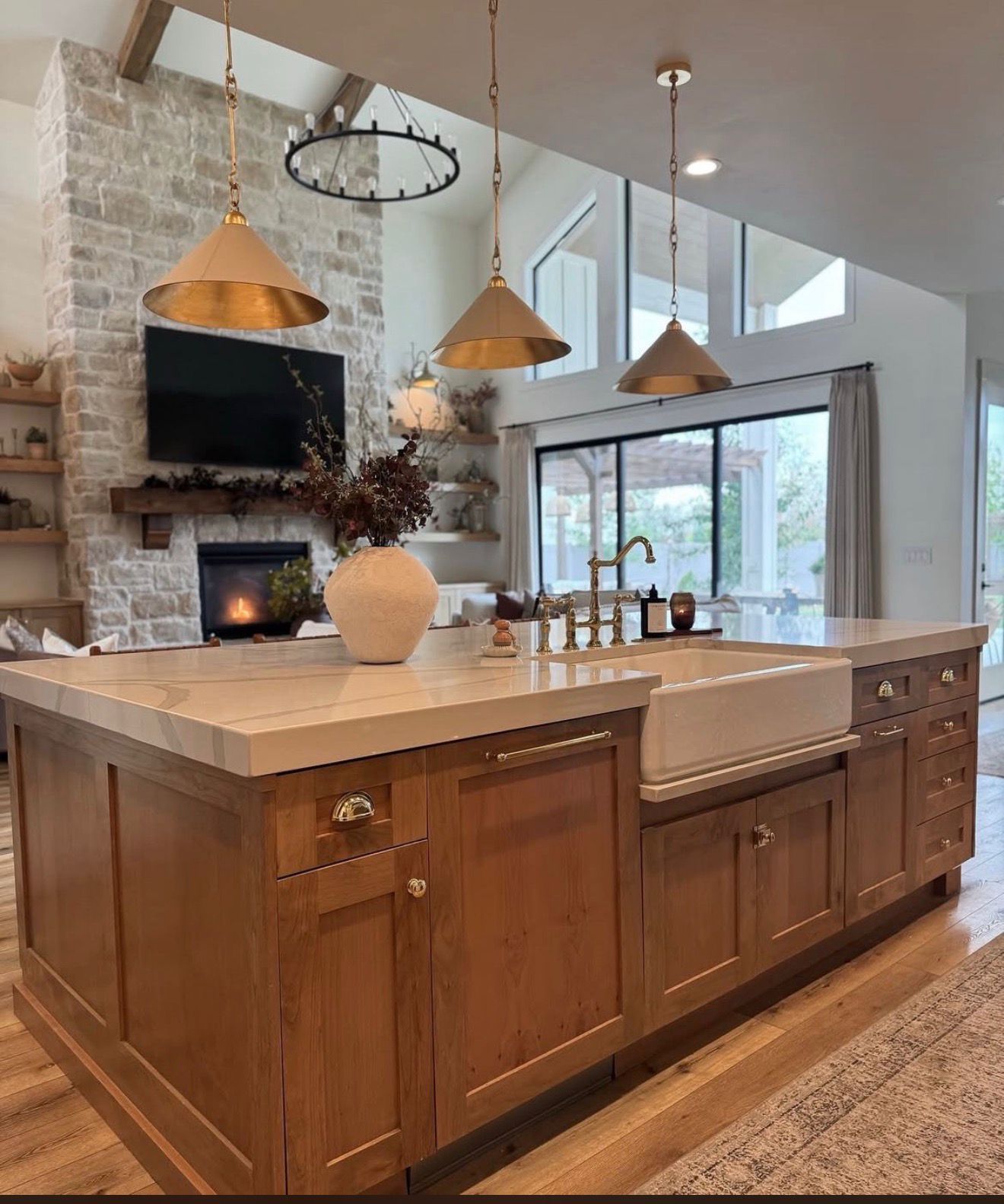 Kitchen island with farmhouse sink and warm pendants